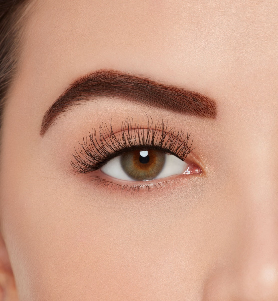 Front view of a model with one eye open wearing Ardell Eco Lashes 451 upper false lashes to show how they look on the eye