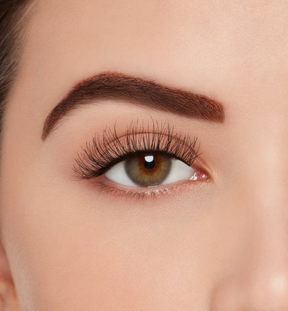 Front view of a model with one eye open wearing Ardell Eco Lashes 451 upper false lashes to show how they look on the eye