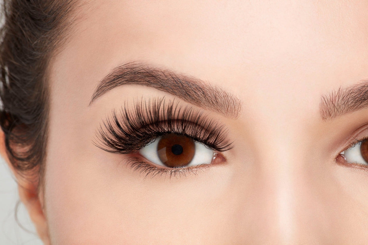 Front view of model with one eye open wearing Ardell 3D Faux Mink 853 to show how they look on the eye