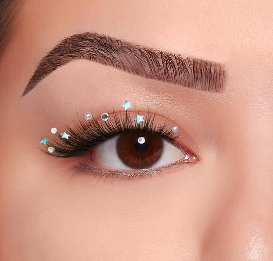 Eye with false lashes and decorative star and gem accents for a festive, glam lash look.